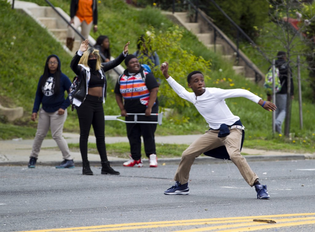 Demonstrators throw rocks at the police after the funeral of Freddie Gray on Monday, April 27, 2015, at New Shiloh Baptist Church in Baltimore. Gray died from spinal injuries about a week after he was arrested and transported in a Baltimore Police Department van. (AP Photo/Jose Luis Magana)