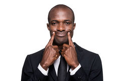 forced-smile-serious-young-african-man-formalwear-making-his-fingers-standing-isolated-white-background-43593212